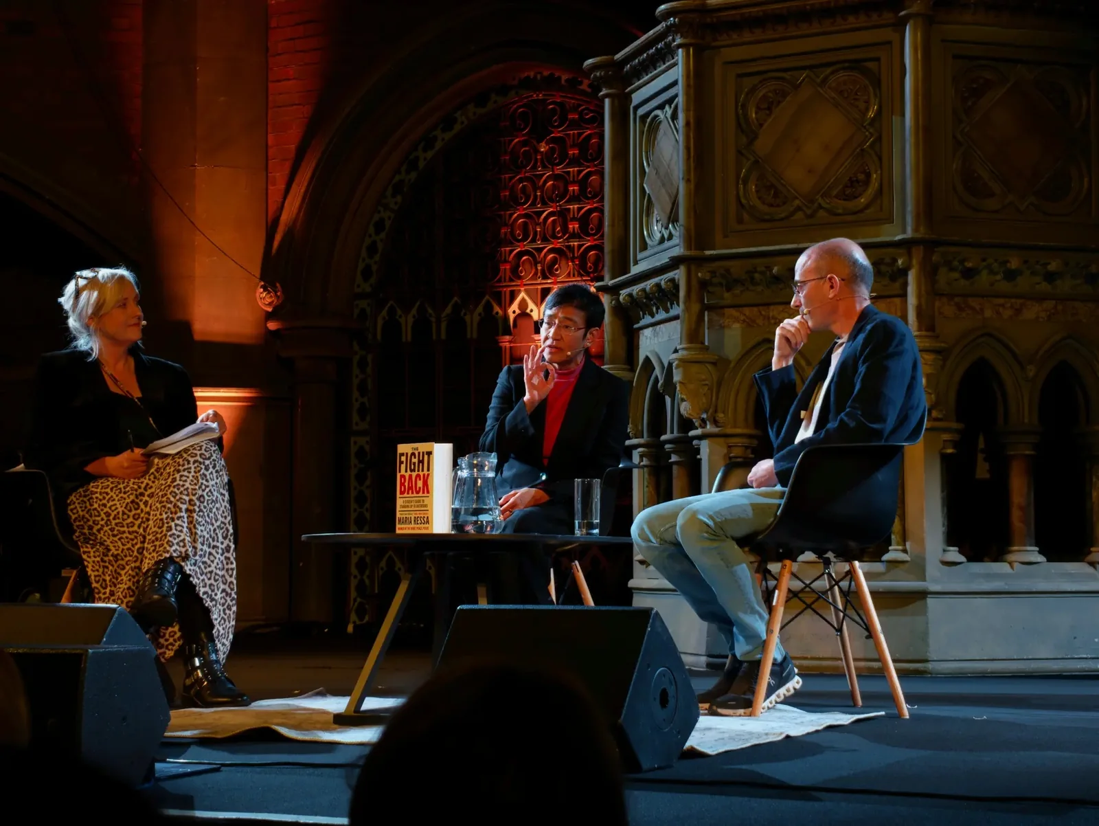 Maria Ressa and Yuval Noah Harari speaking with the event host on stage